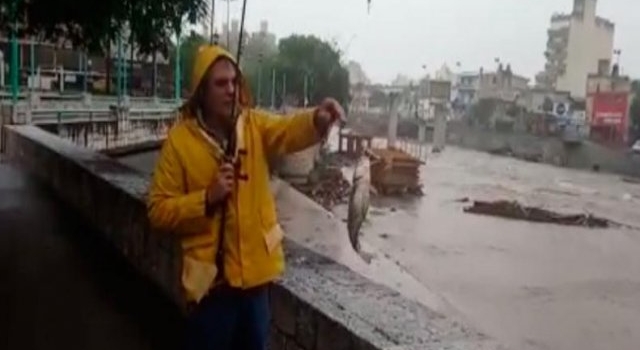 ¡La imagen del día! Bajo la lluvia, pescaron viejas del agua en pleno Río Suquía